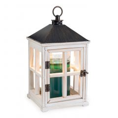 White wooden lantern candle warmer with a candle glowing inside